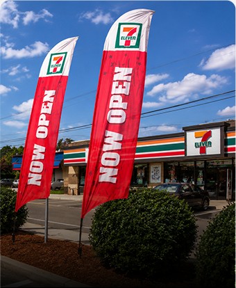 Now Open feather flags outside a 7-Eleven store