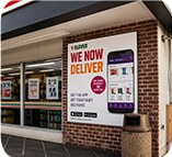 7-Eleven storefront We Now Deliver banner